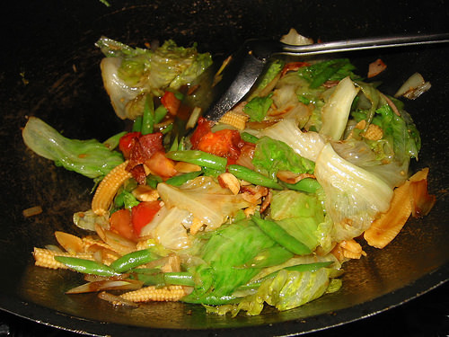 Stir-fried vegetables with leftover bacon and tomato in the wok