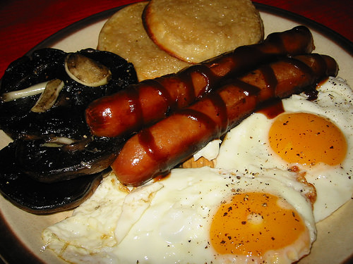 Sausages, fried eggs, buttered crumpets and panfried garlic mushrooms