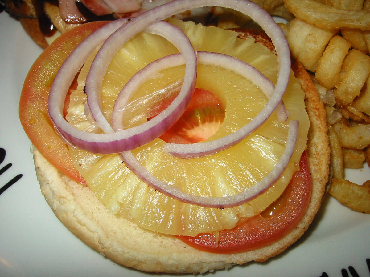 Bun lid with tomato, pineapple and red onion rings