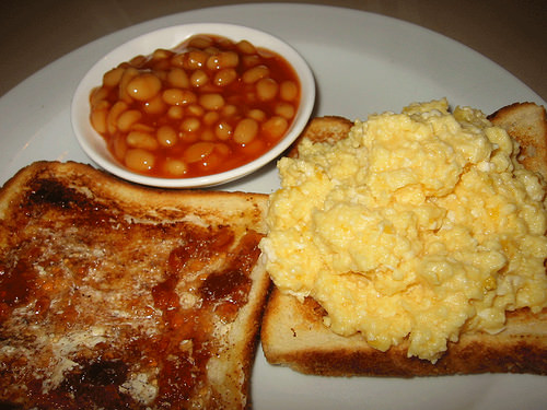 Scrambled eggs on toast, strawberry jam and canola spread on toast, baked beans