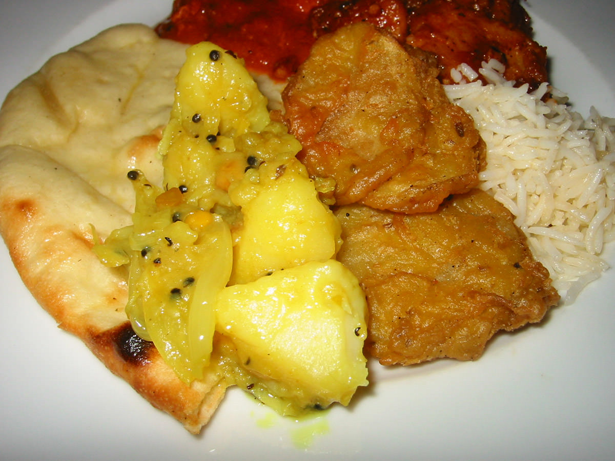 Close-up of naan bread, potatoes and rice