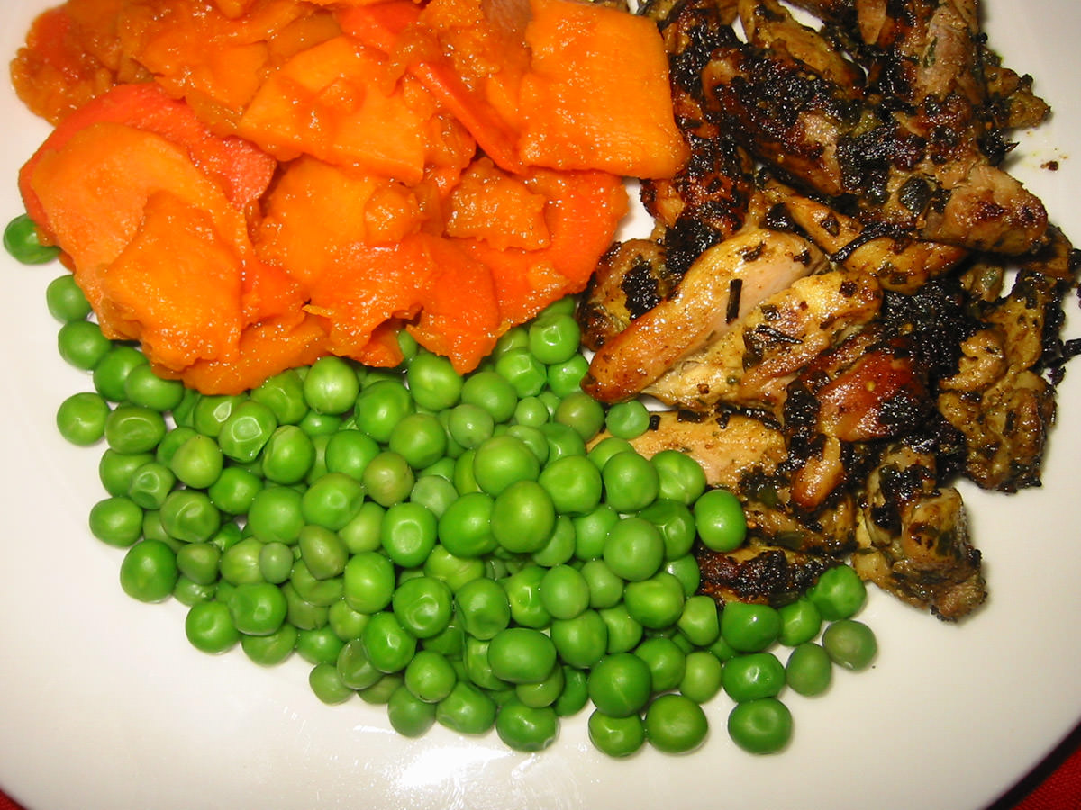 Panfried lemon pepper chicken, served with peas and steamed sweet potatoes and carrots