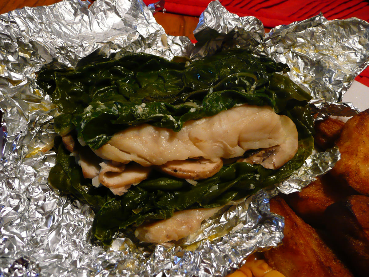 Close up of baked fish, mushrooms and spinach