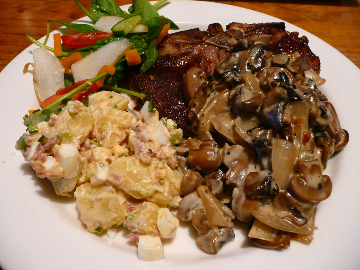 T-bone steak with creamy mushroom sauce, potato salad and spinach and pear salad