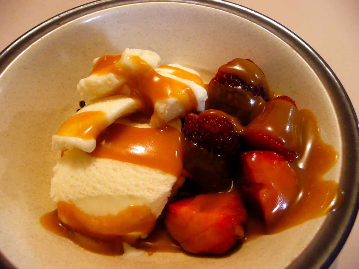 Vanilla ice cream with strawberries and caramel sauce
