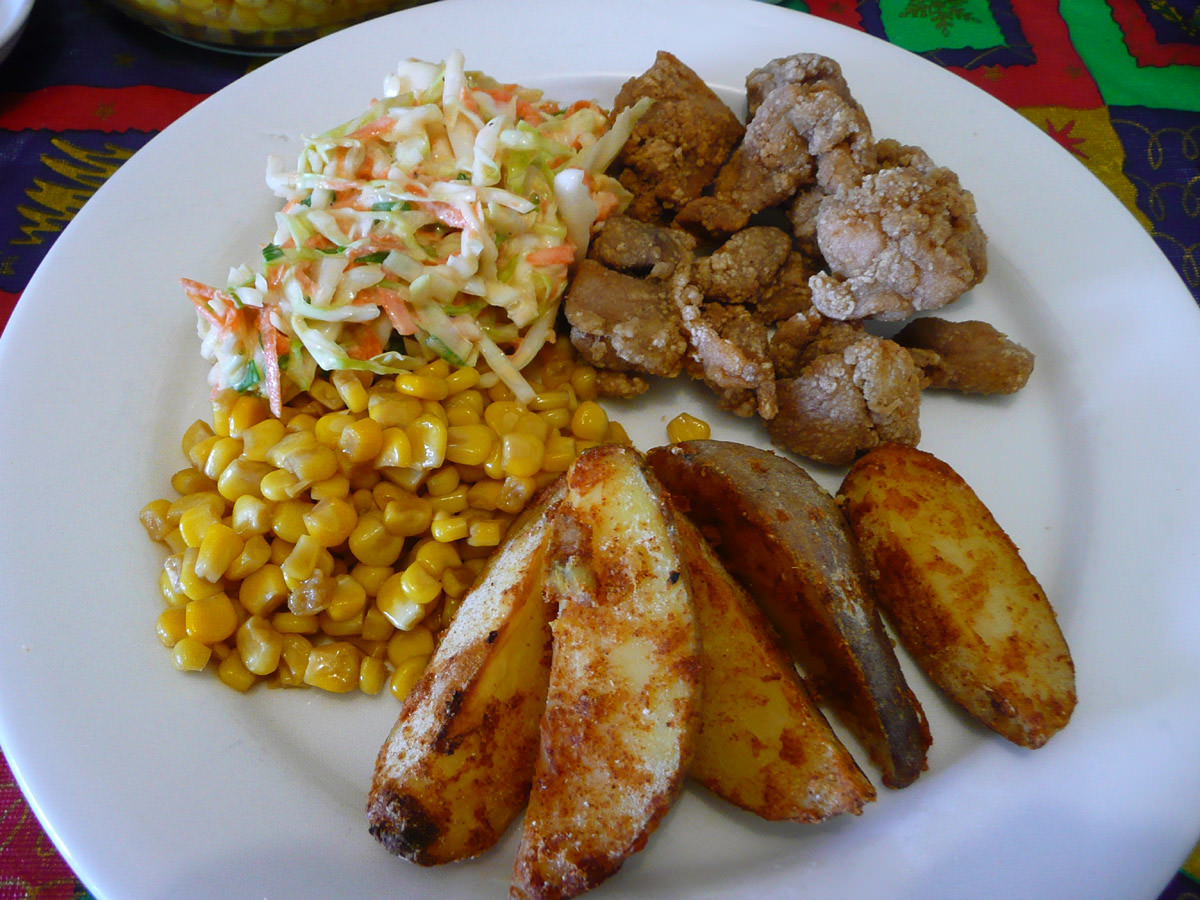 Fried chicken, potato wedges, coleslaw and butter corn
