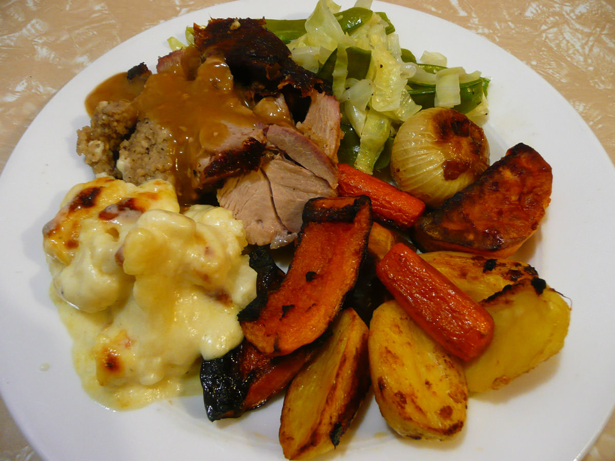 Rolled turkey roast with roast vegetables, steamed greens and cauliflower cheese