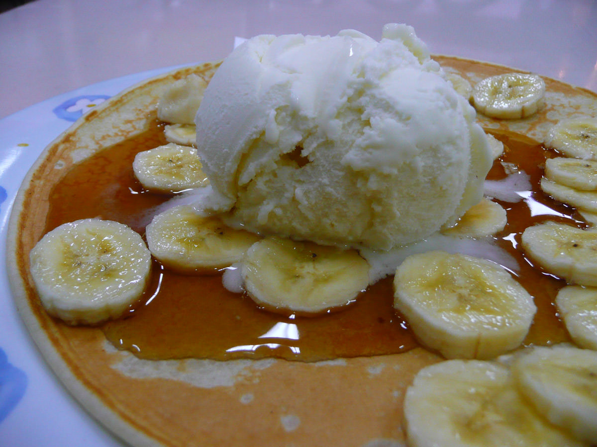 Pancake with ice cream, banana and maple syrup close-up