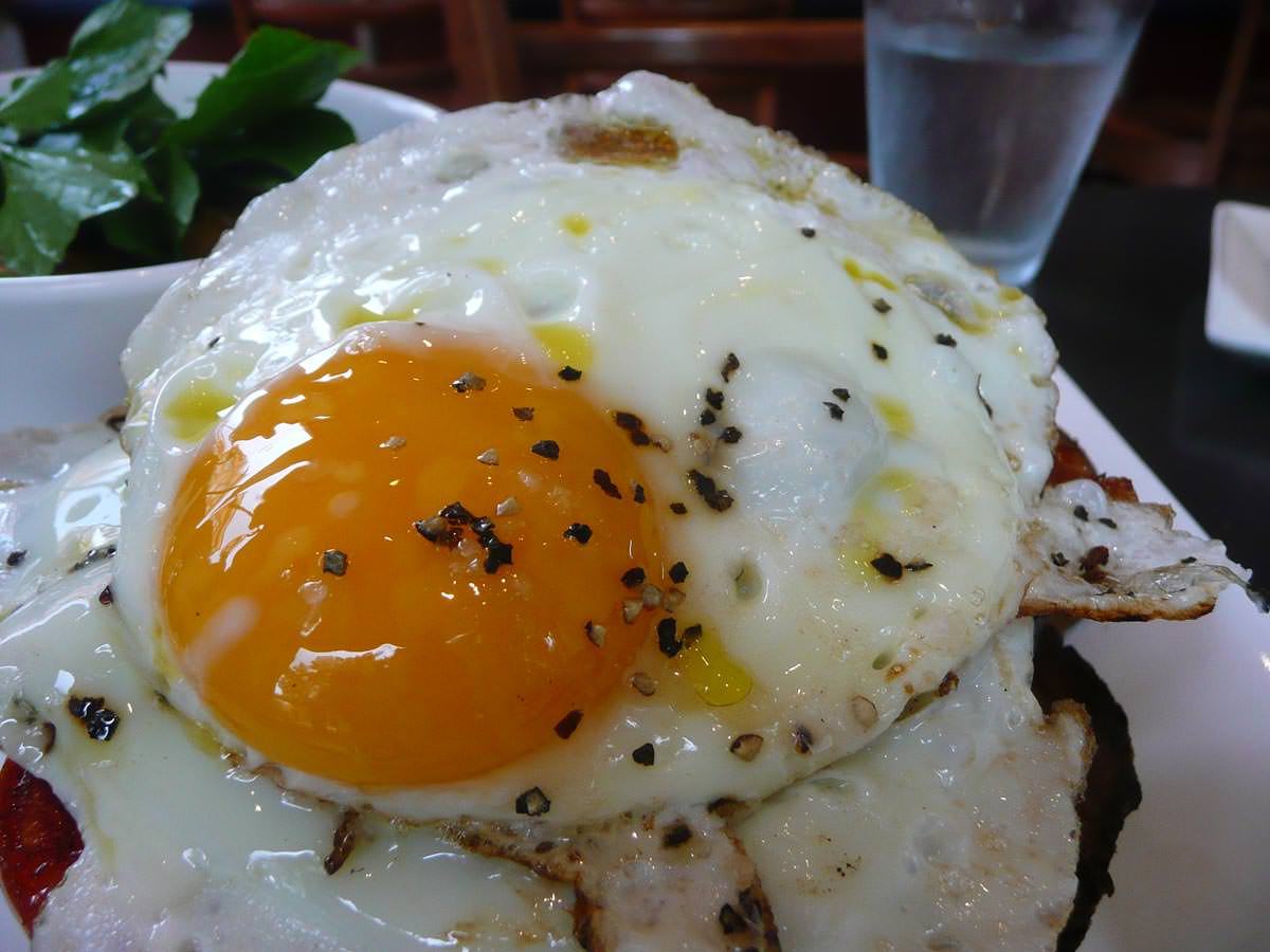 A beautiful fried egg with gooey yolk, topped with freshly cracked black pepper