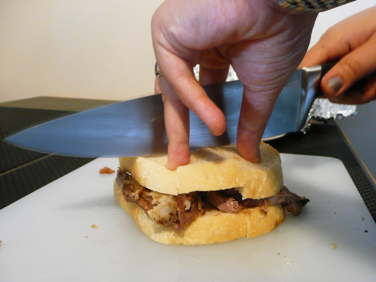 Carefully cutting the roast beef sandwich in half