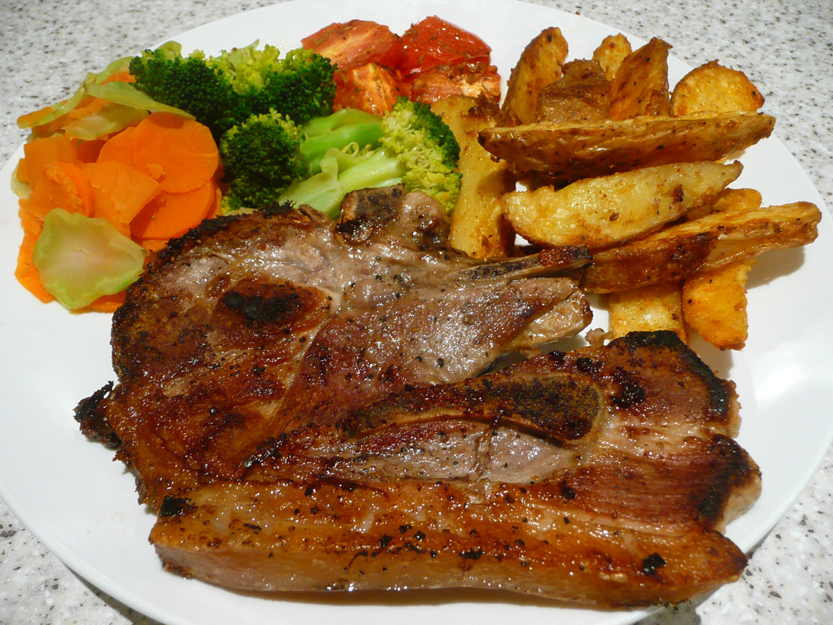 Dinner - pork chop, roasted tomato, steamed vegetables and potato wedges