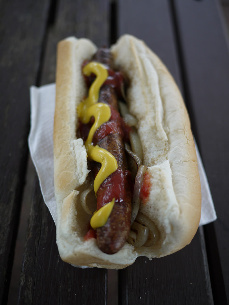 Sausage sizzle - hot dog with onions, tomatoes and mustard