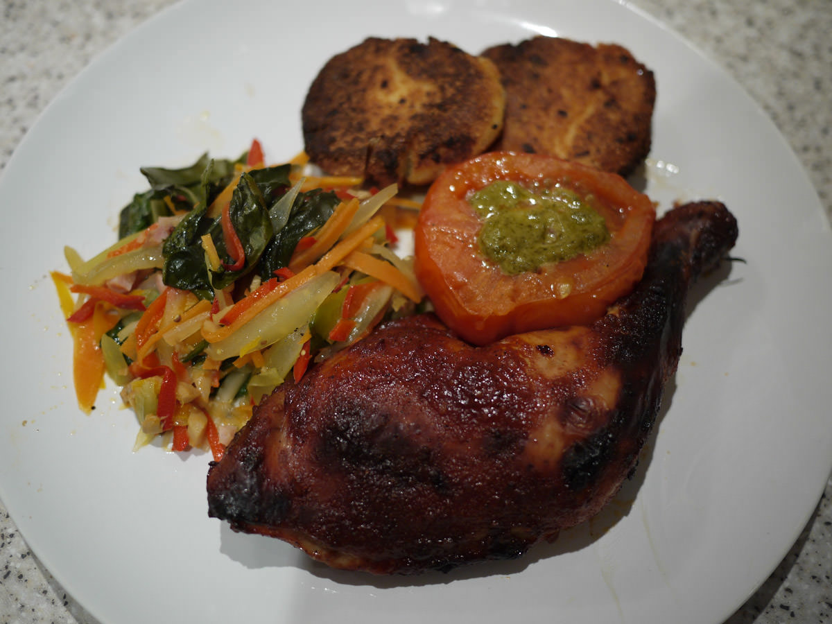 Oven-baked chicken and vegetables, tomato with pesto, potato cakes