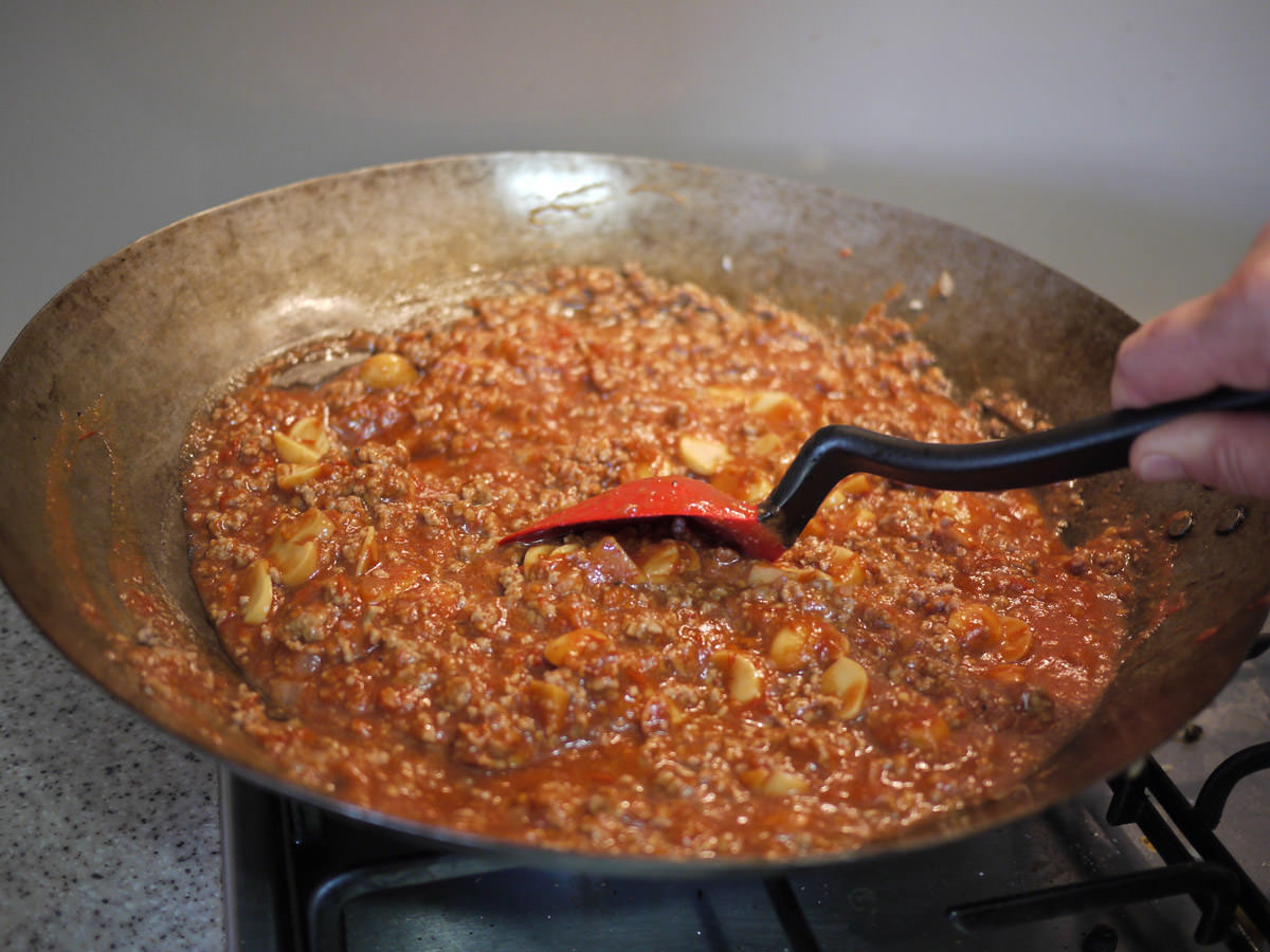 Stirring the bolognese sauce using the supoon