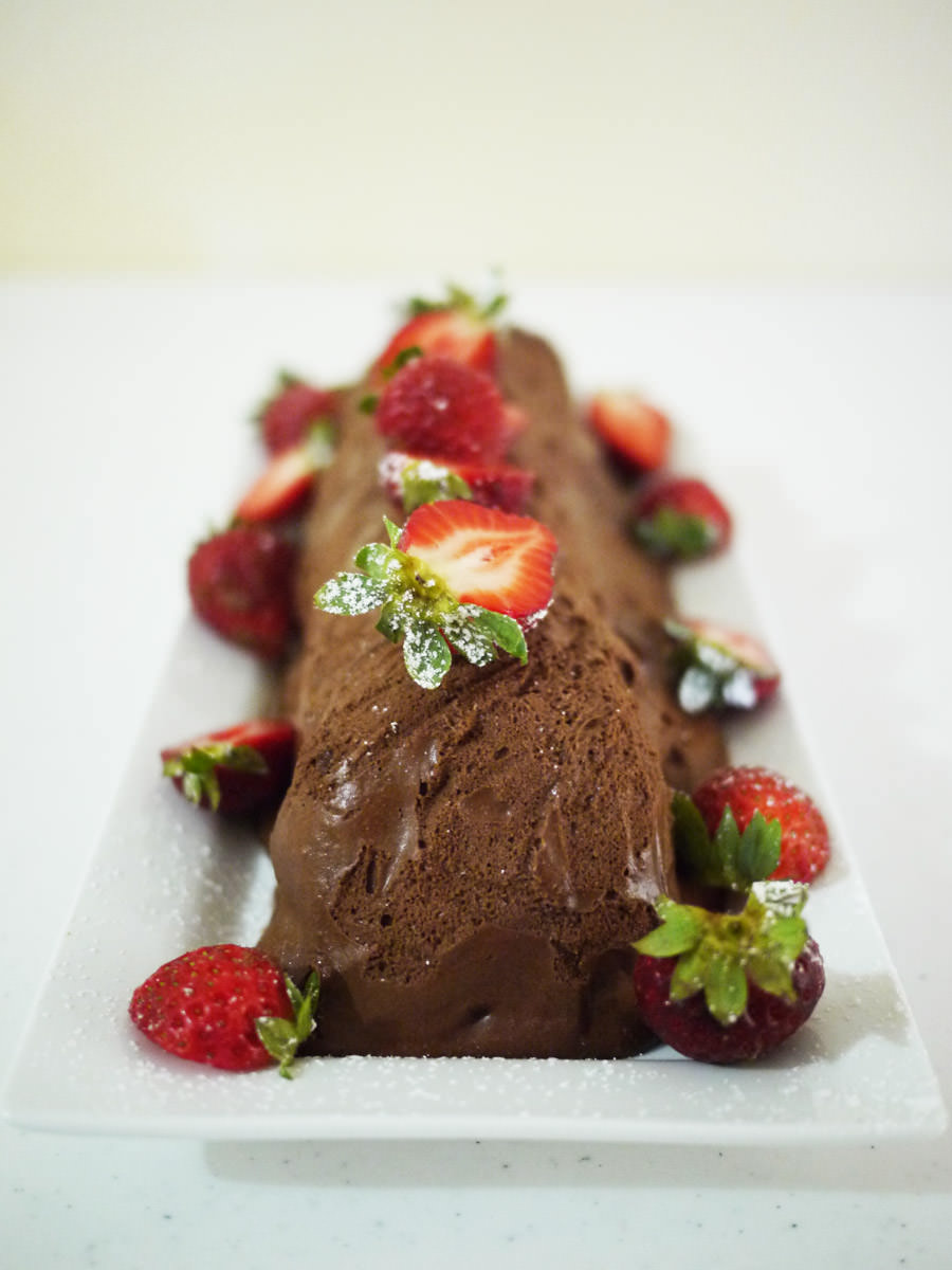 Chocolate mousse log, decorated with strawberries
