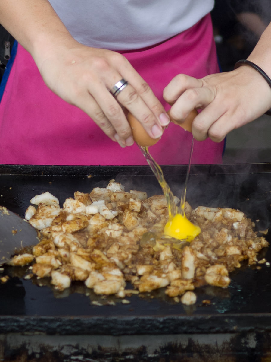Breaking an egg into the char kway