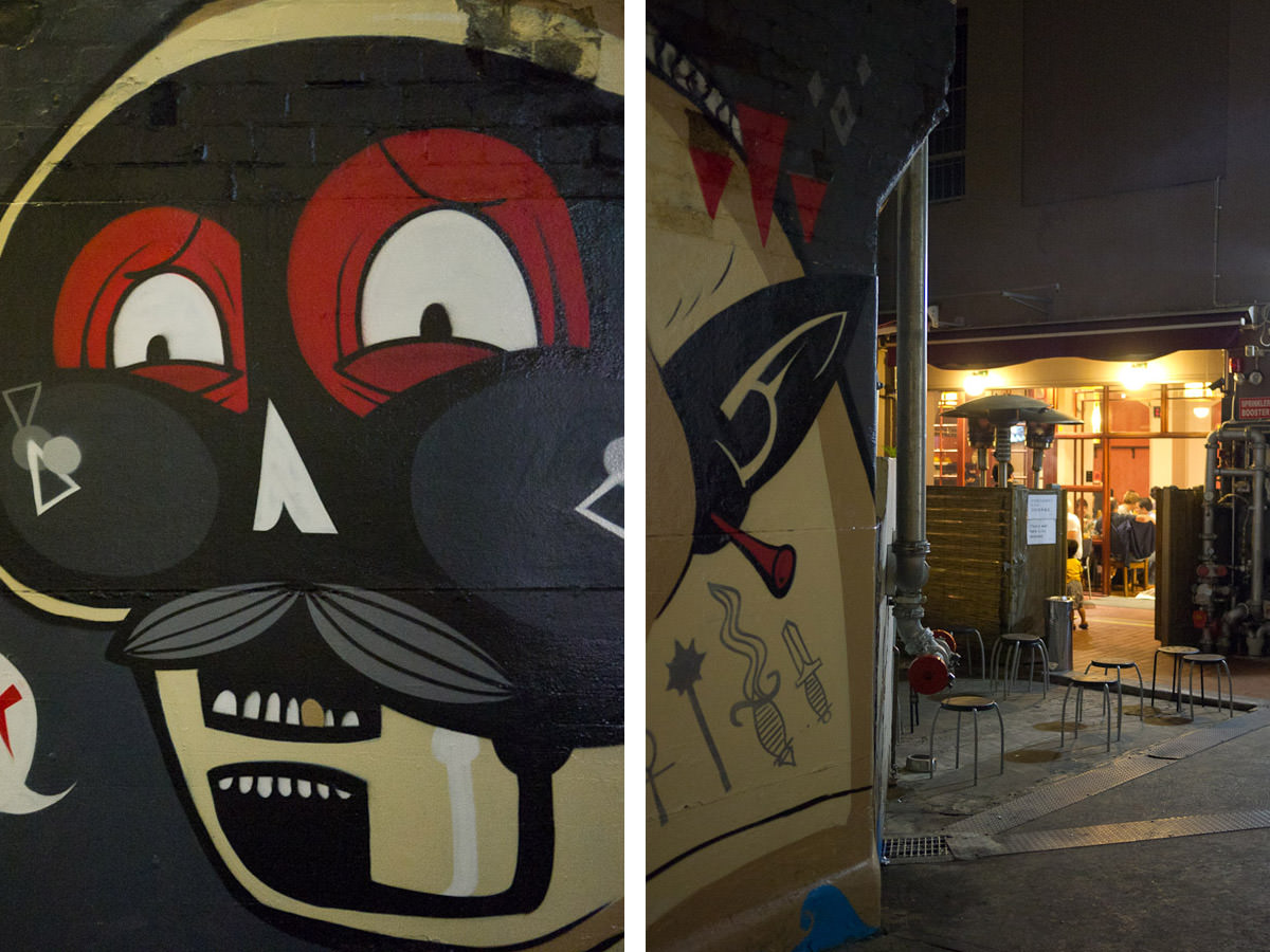 Graffiti art and empty stools outside Sydney Madang