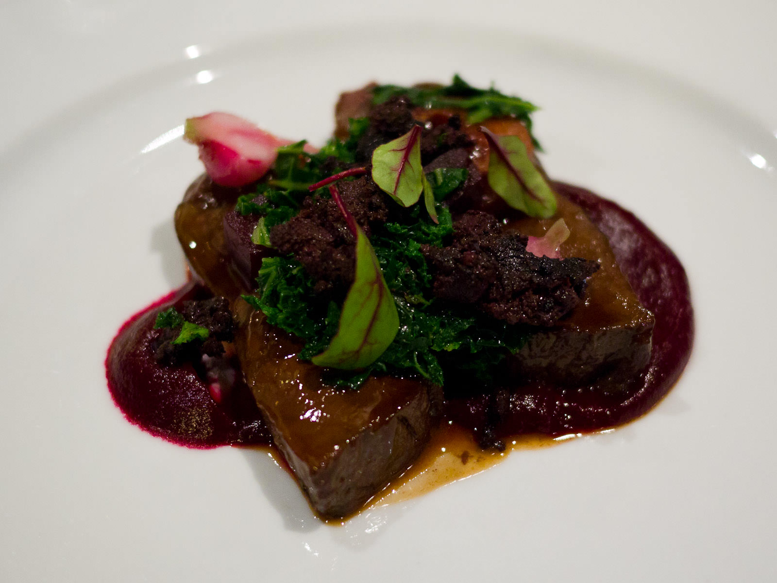 Oven roasted venison rump with black pudding, beetroot, plums and seared kale