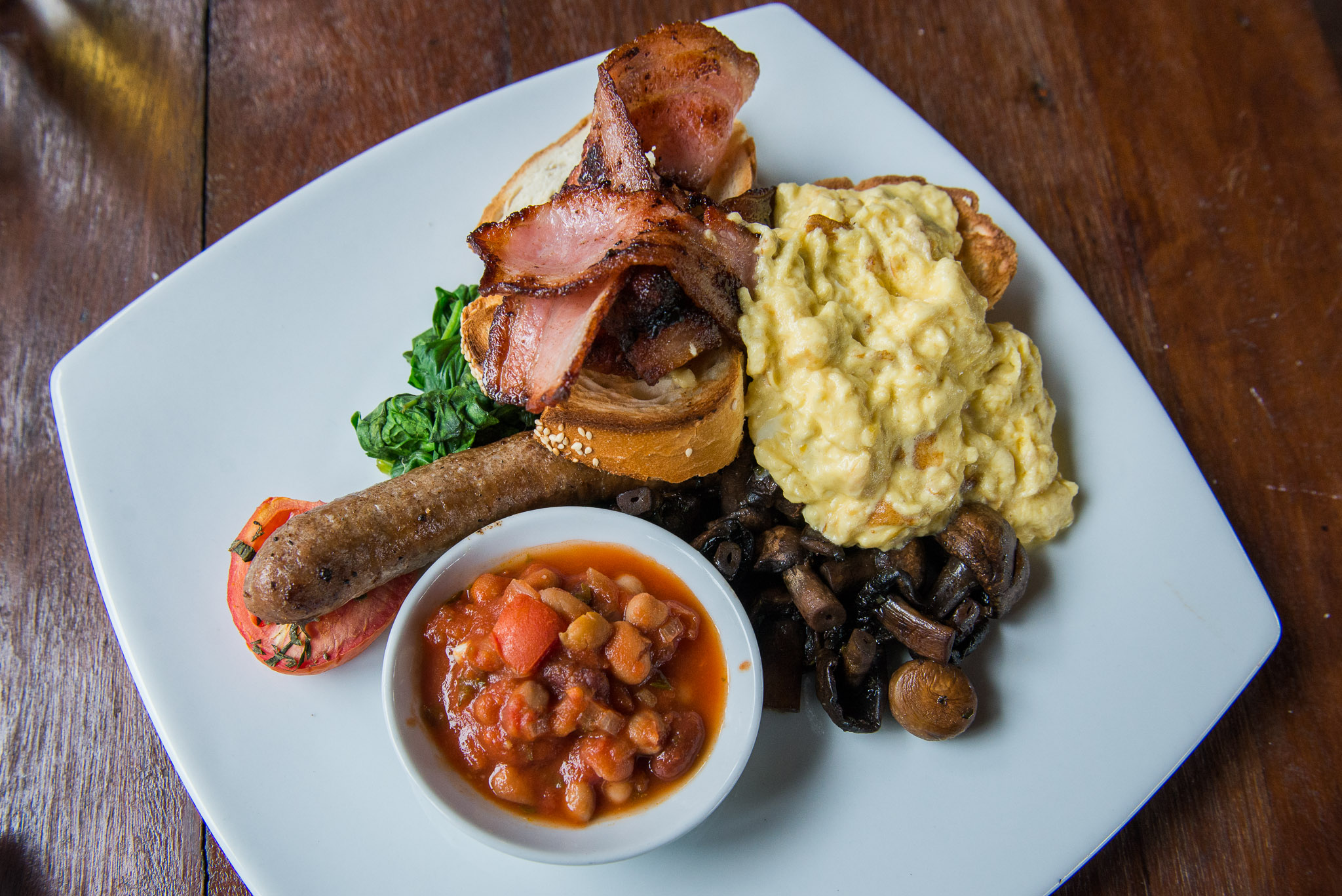 Full breakfast - bacon, sausage, egg, confit tomato, garlic & herb mushroom, wilted spinach, toast, homemade baked beans (AU$22)