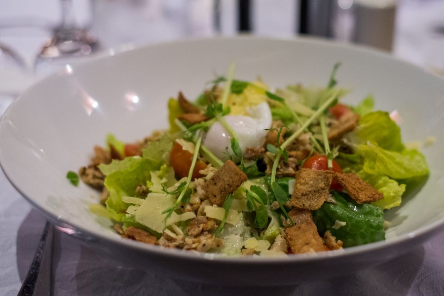 El Caballo Caesar salad - herb grilled chicken, crisp cos lettuce, shaved parmesan, cherry tomatoes, gooey poached egg and anchovy dressing (AU$12)