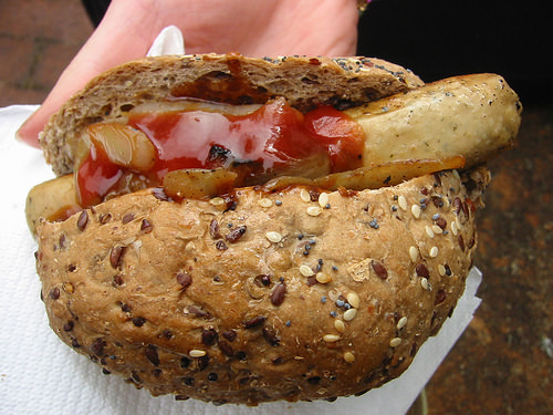 Vegetarian sausage, onions, tomato sauce and a grainy bun