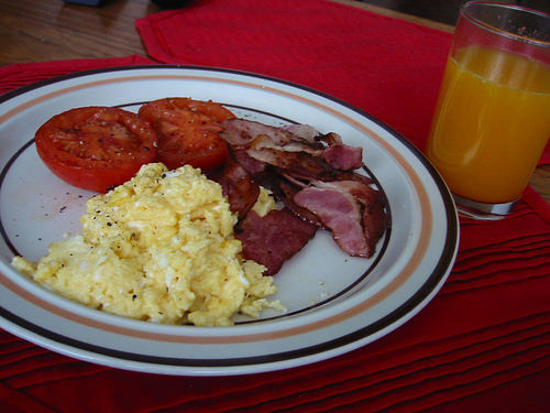 Bacon, scrambled eggs, fried tomato and freshly squeezed orange juice