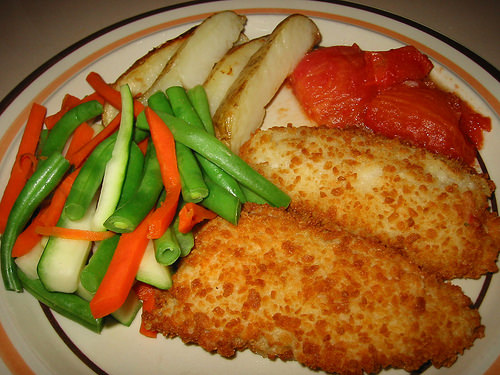 Crunchy potato-coated fish filets, steamed veg, potatoes and baked tomato