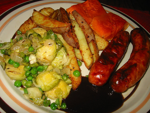 Baked sausages, pumpkin, potato wedges and fried brussels sprouts