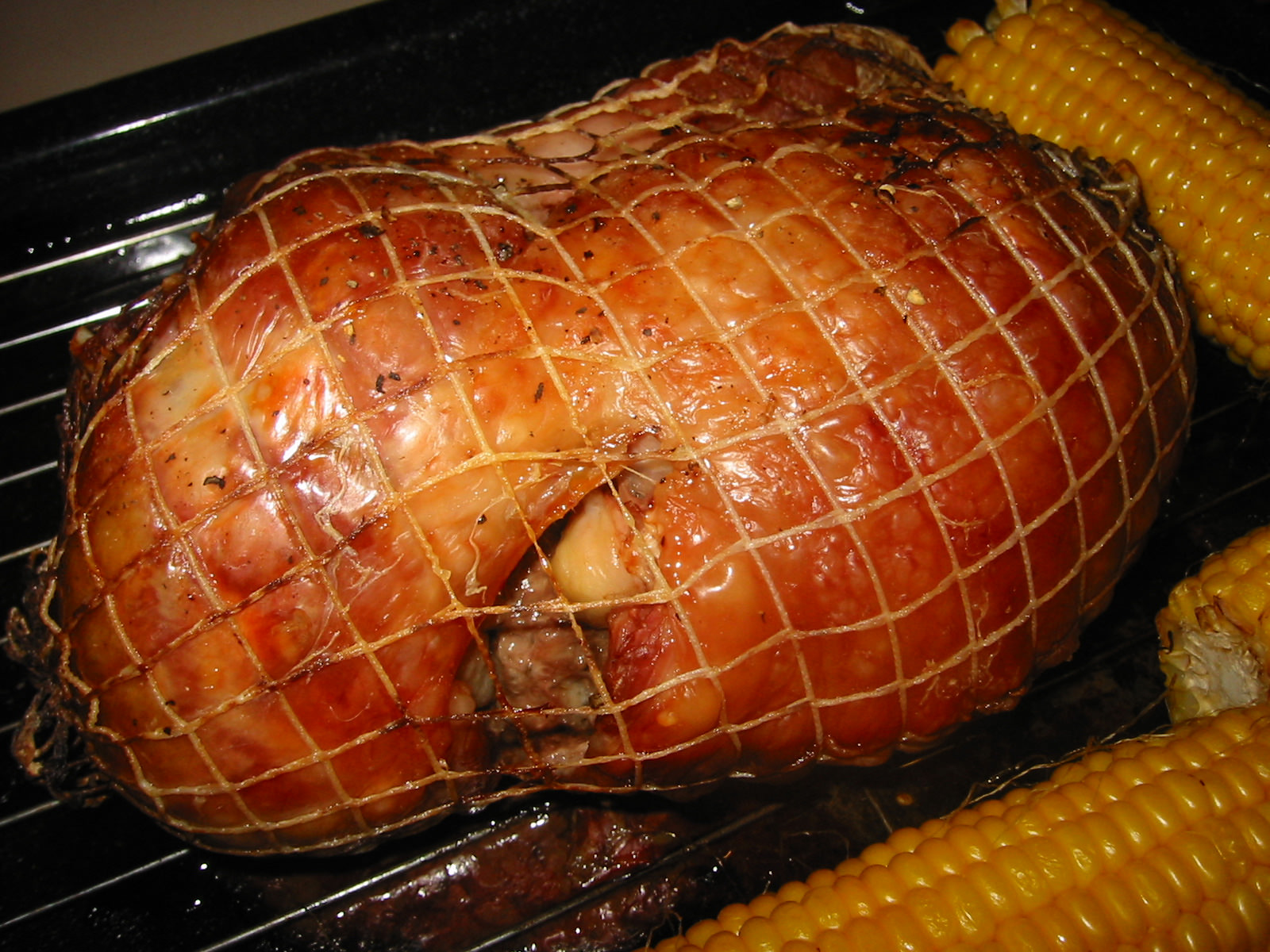 Turkey thigh roast, flanked by roasted corn on the cob