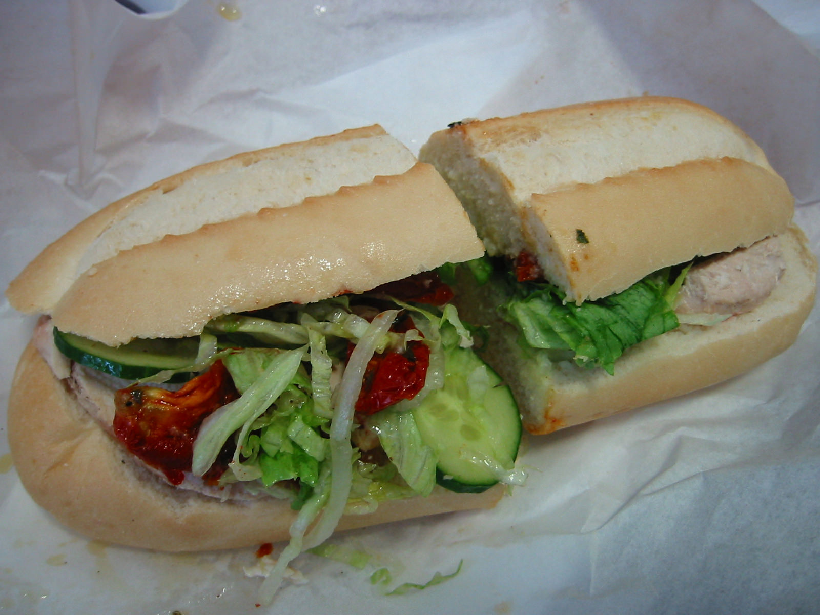 Bread roll with chicken, cucumber, lettuce and sundried tomatoes