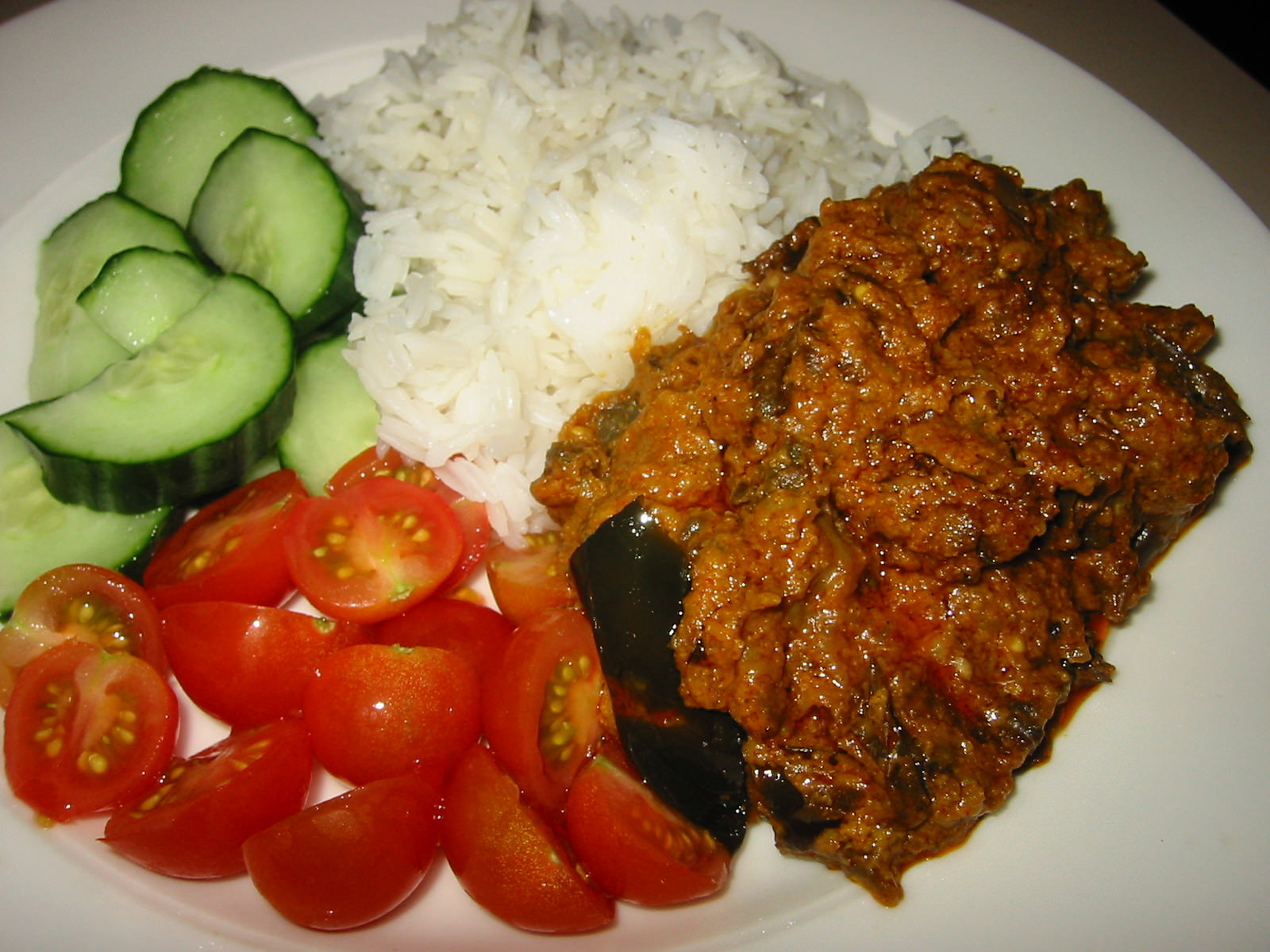 Leftover brinjal bhaji with rice, fresh tomatoes and cucumber