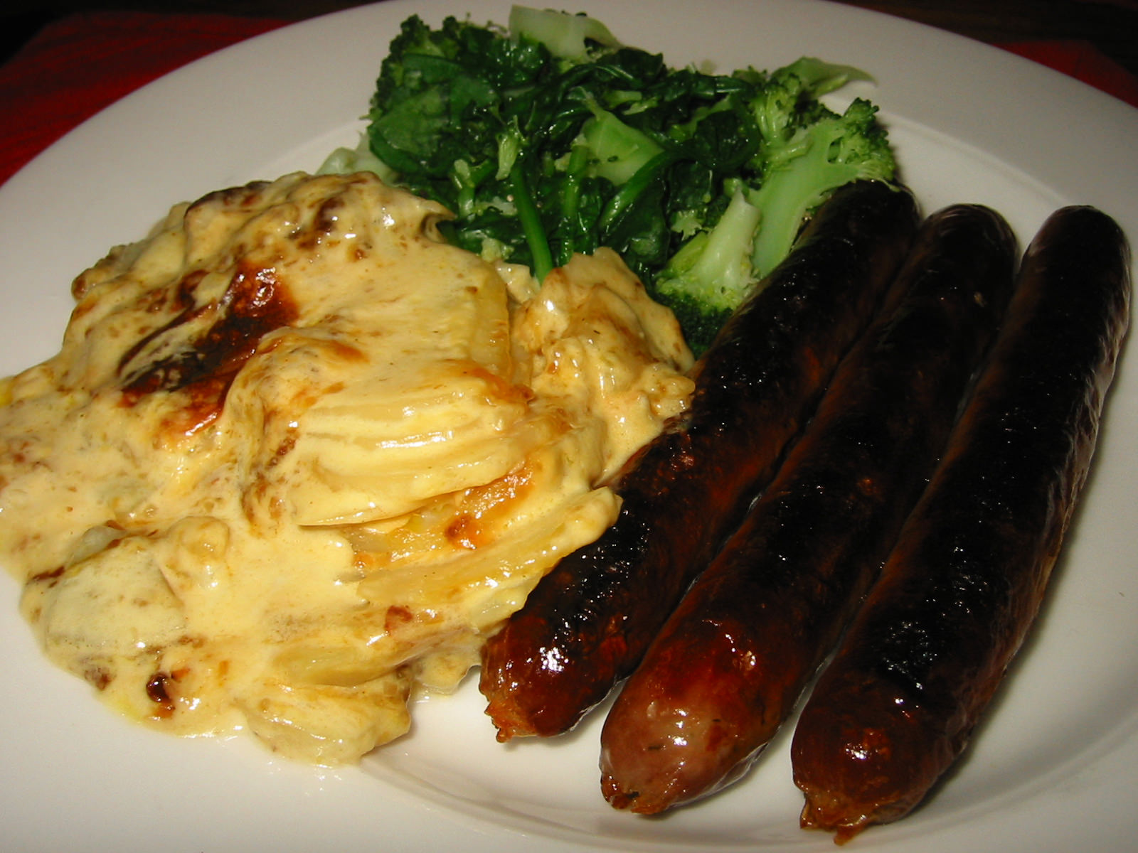 Sausages, potato bake and steamed broccoli and English spinach