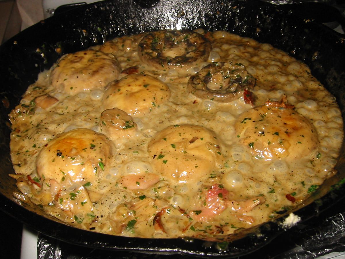 Mushrooms and bacon in cream and white wine sauce in the pan