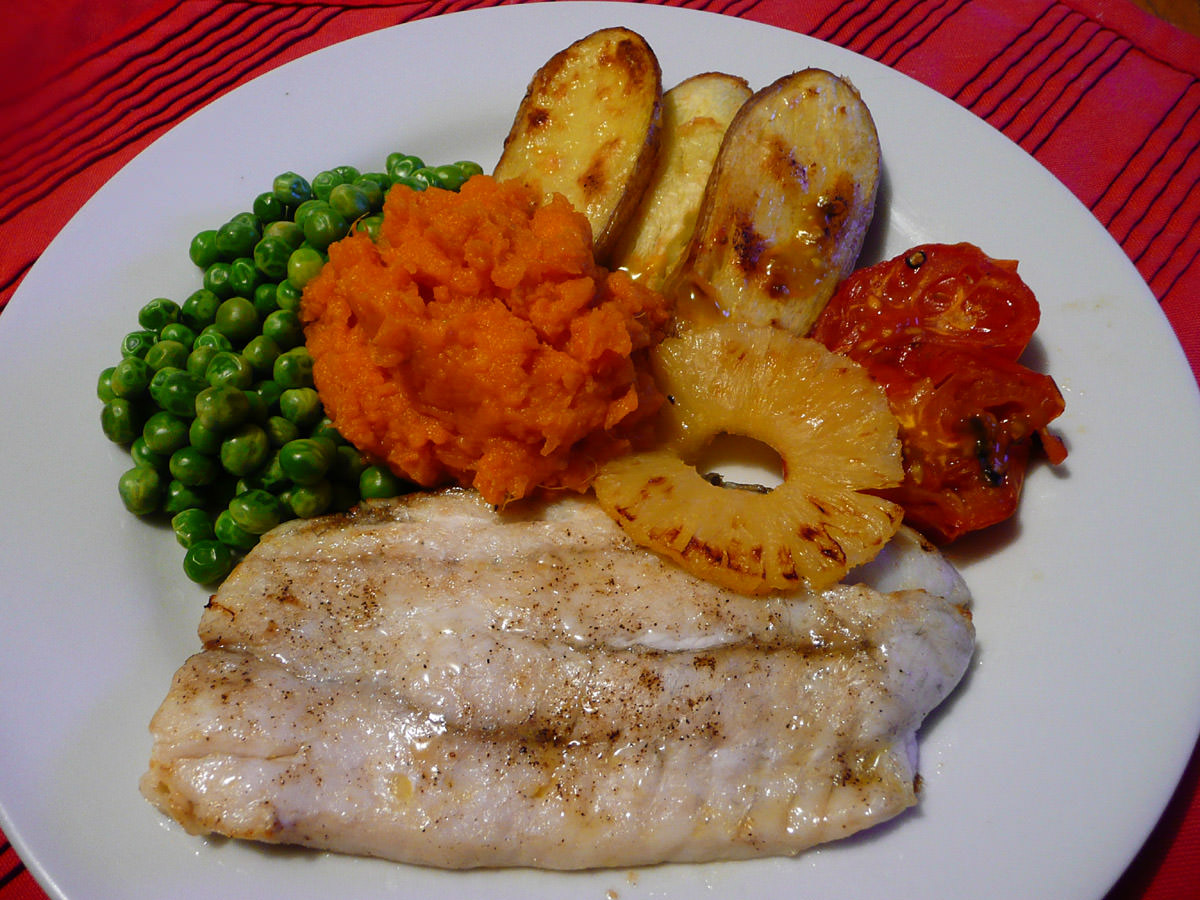 Grilled snapper, grilled potatoes, tomato and pineapple, with orange mash and peas