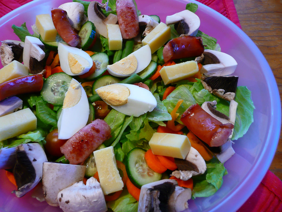 Salad with hard-boiled egg, tasty cheese and fried cabanossi