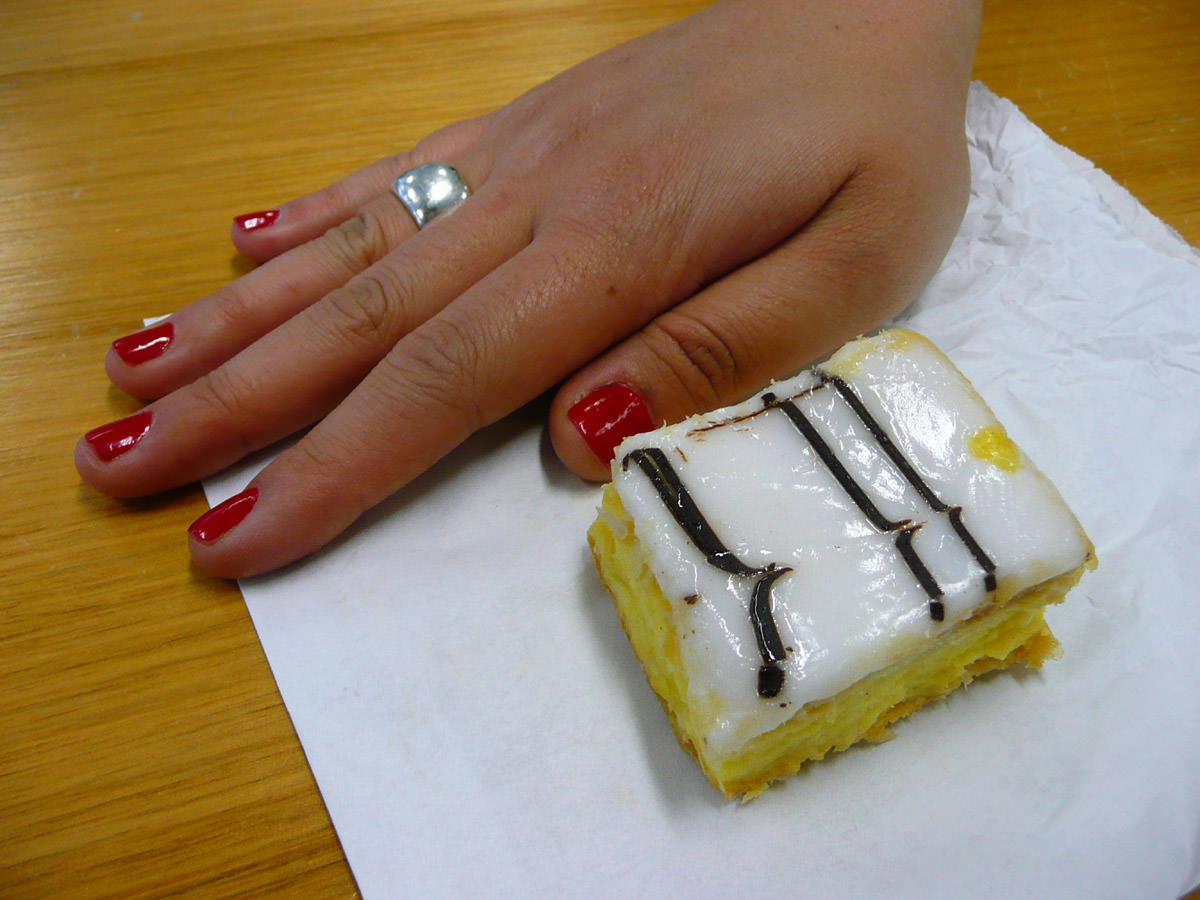Vanilla slice with a hand to indicate size