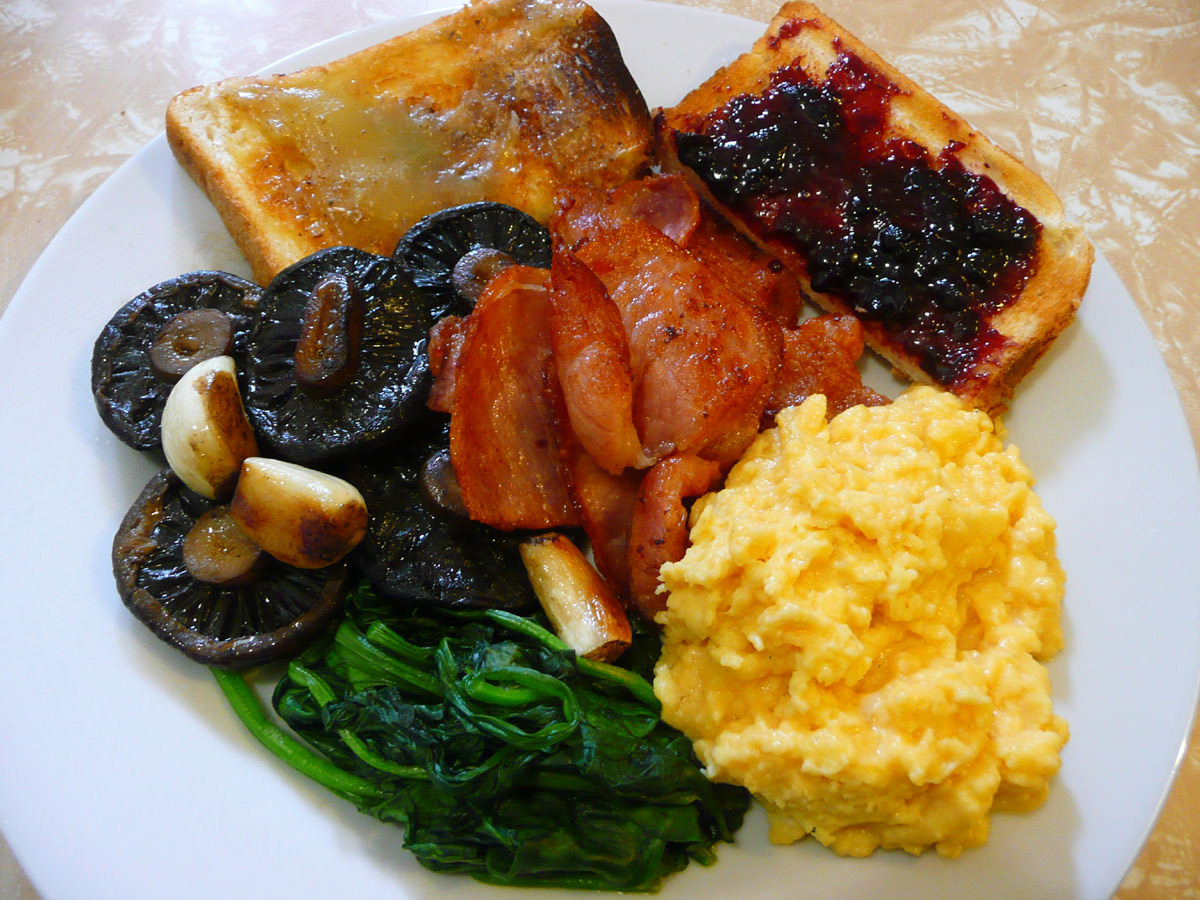Fry-up with bacon, garlic mushrooms, scrambled eggs, spinach and toast