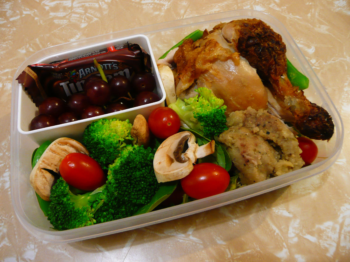 Bento - barbecue chicken, stuffing, salad, grapes and Tim Tam