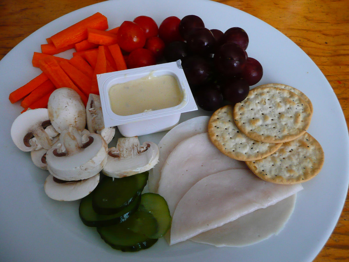 Crackers, vegetables, cold sliced turkey, pickles and French onion dip