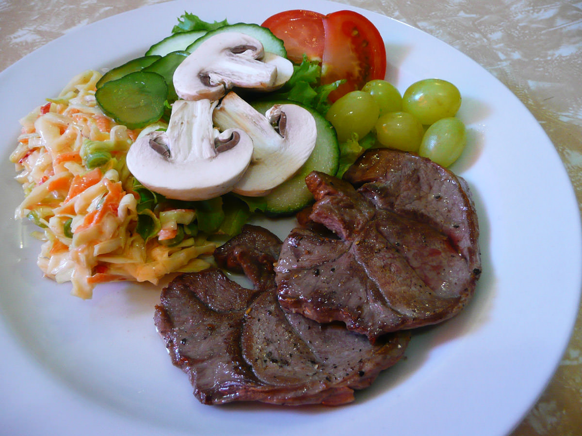 Lamb steaks, salad, coleslaw and grapes