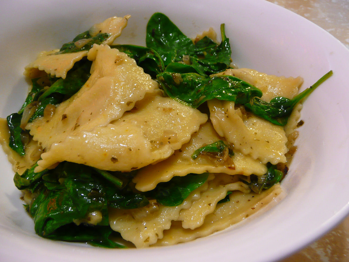 Seafood ravioli with baby spinach with olive oil, fried onion and garlic