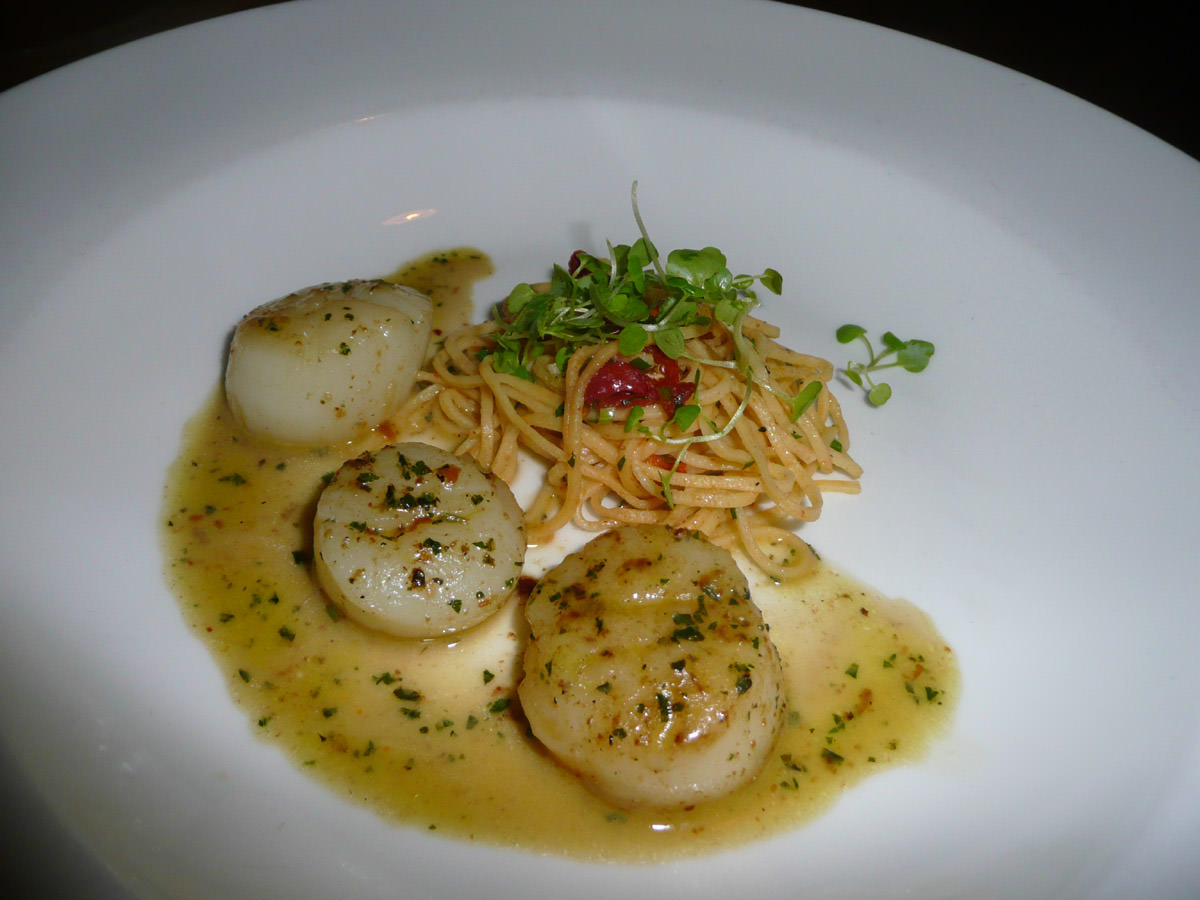 Sea scallops seared in pesto basil butter with angel hair pasta and sundried tomatoes