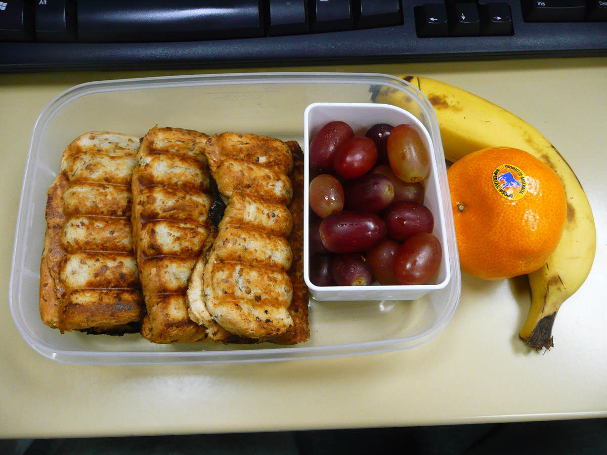 A sort of breakfast bento - toasted sandwiches and fruit