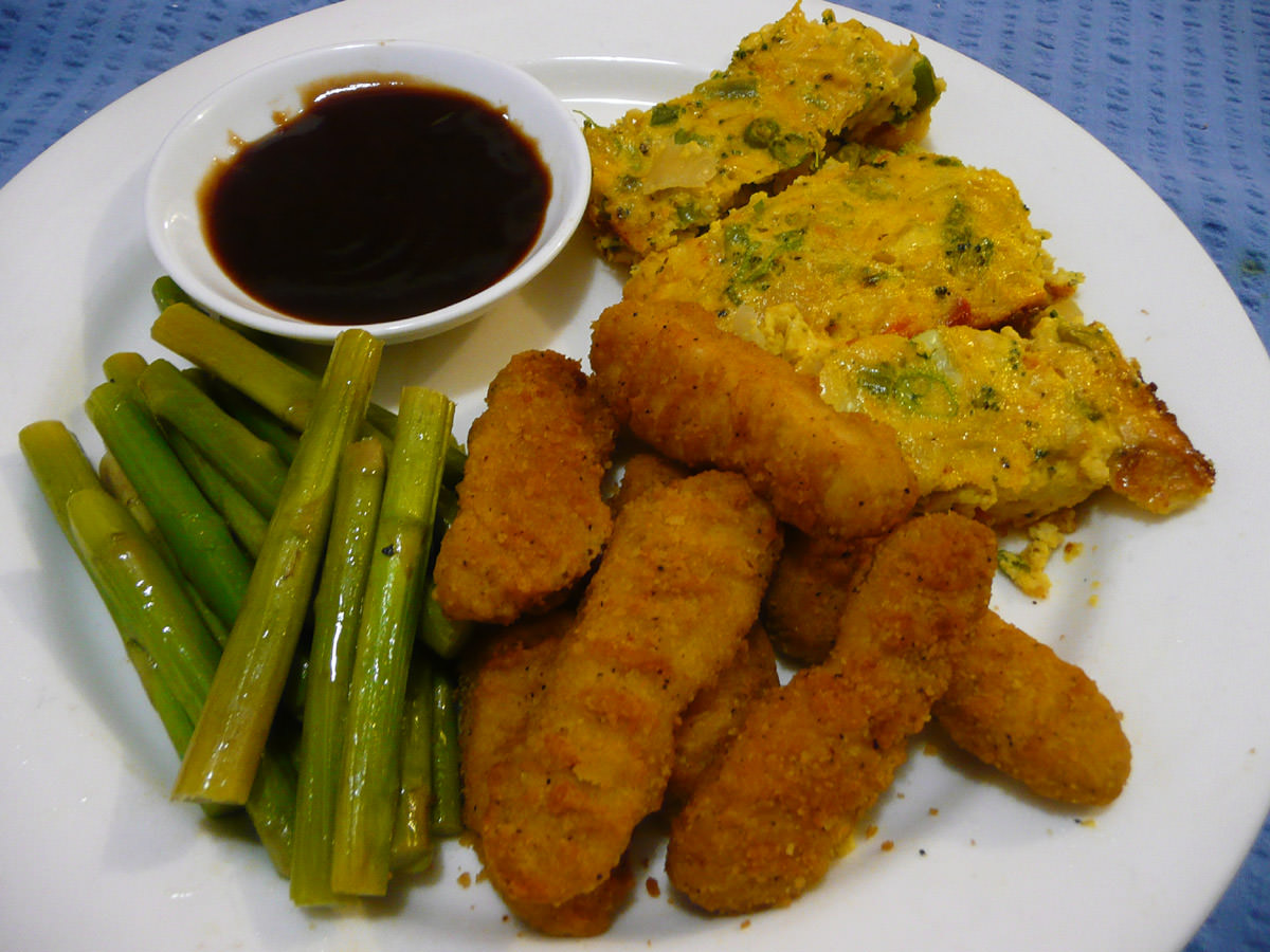 Chicken fingers, asparagus stems, vegetable slice, BBQ sauce
