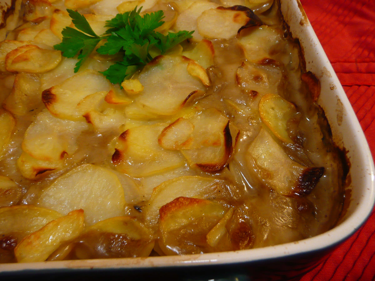 Baked chicken and mushroom casserole topped with sliced potatoes