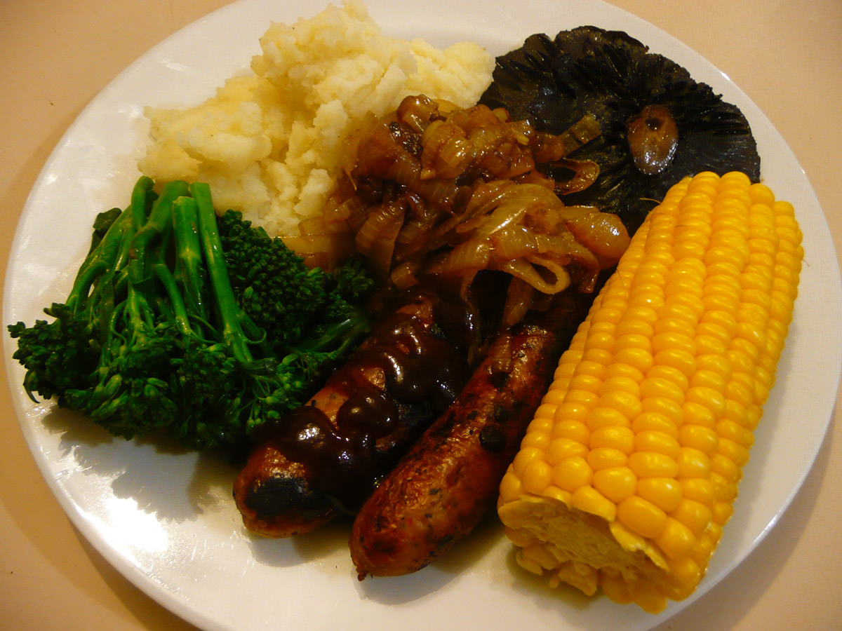 Sausages and mashed potatoes, fried onions, corn, portabello mushrooms and broccolini