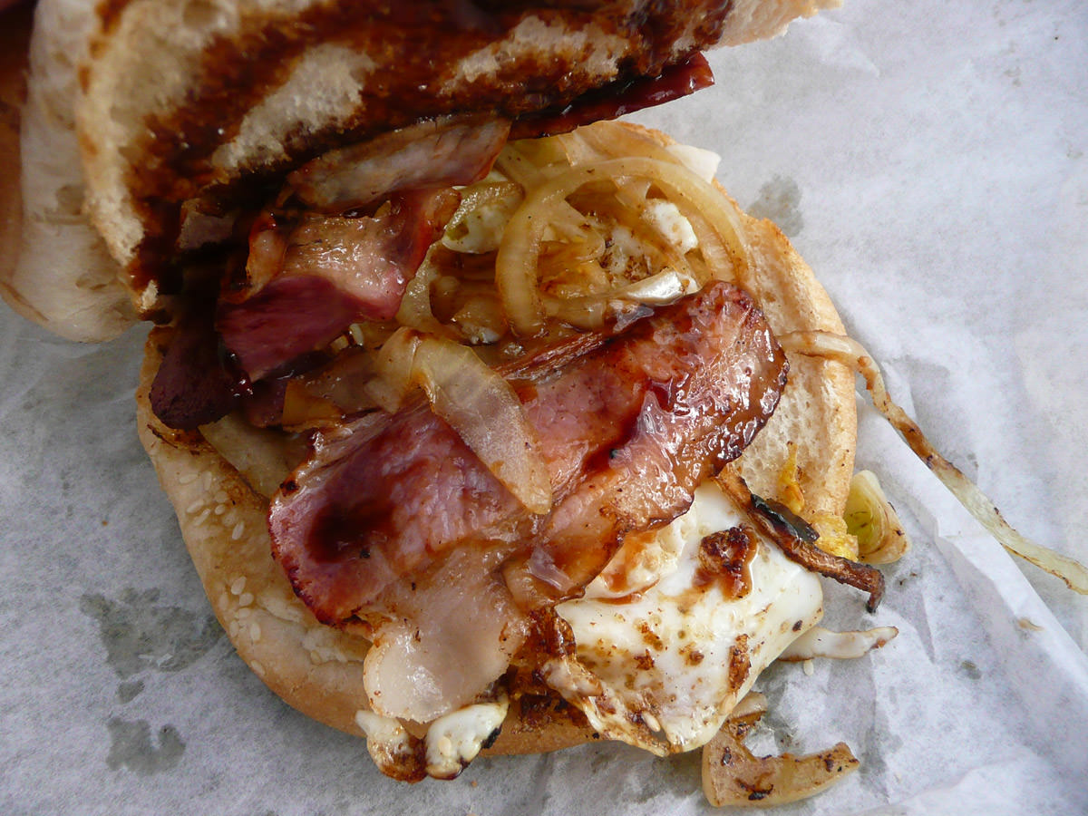 Bacon and egg burger with fried onions and BBQ sauce innards