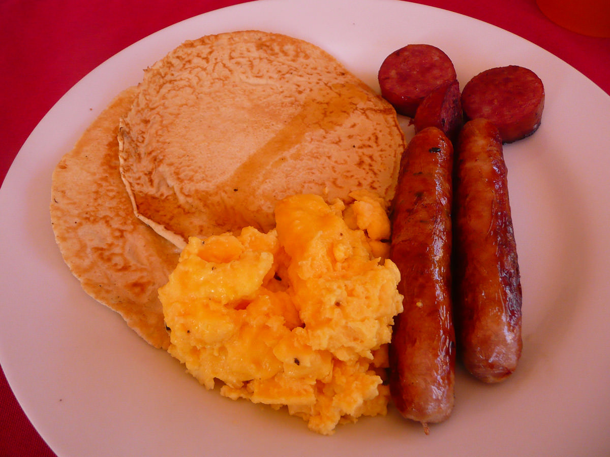 Leftover pancakes with maple syrup, sausage, scrambled eggs