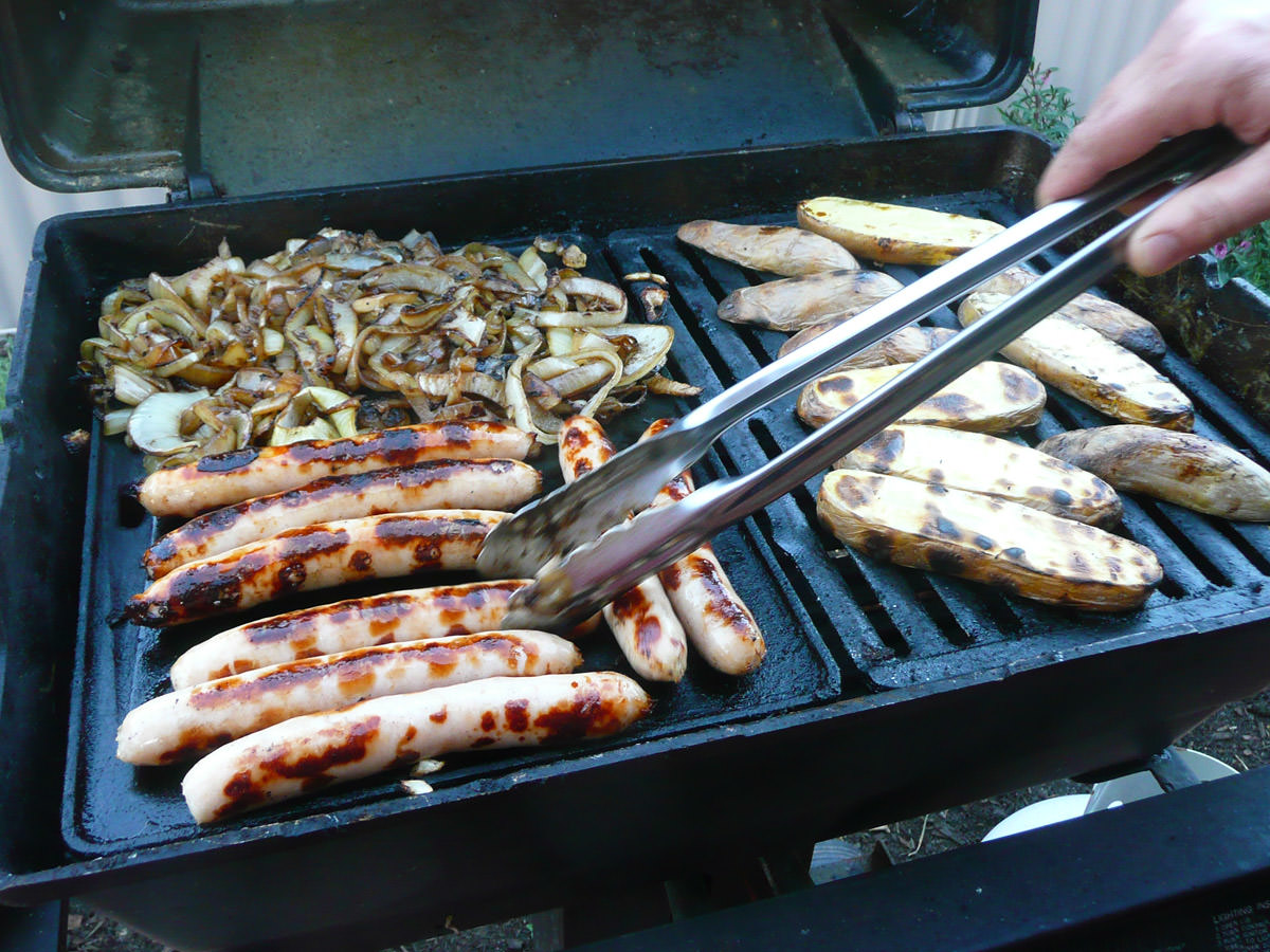Sausages, onions and potatoes on the barbecue