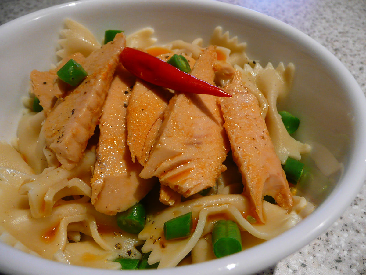 Tuna in chilli oil with bow pasta and green beans close-up